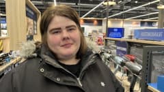 Lahtelainen Anni Lehikoinen katsoo kameraan Gigantin myymälässä, talvitakki yllään, ruskeat hiukset, vahvat kulmakarvat.