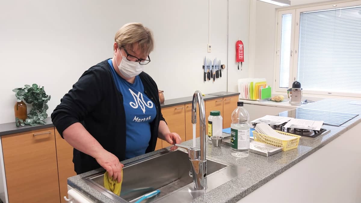 Kotitalousasiantuntija Riitta Sutinen puhdistaa keittiön lavuaaria.
