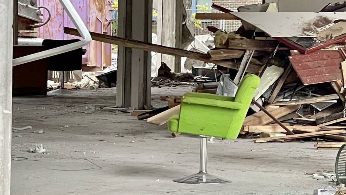 Vihreä tuoli keskellä rakennusta, joka on osittain purettu.