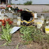 Tienvarren muistopaikalla on moottoripyörän kypärä ja paljon hautakynttilöitä sekä kukkakimppuja. 