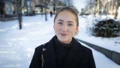 Nuori nainen kaupungilla lumisessa maisemassa.