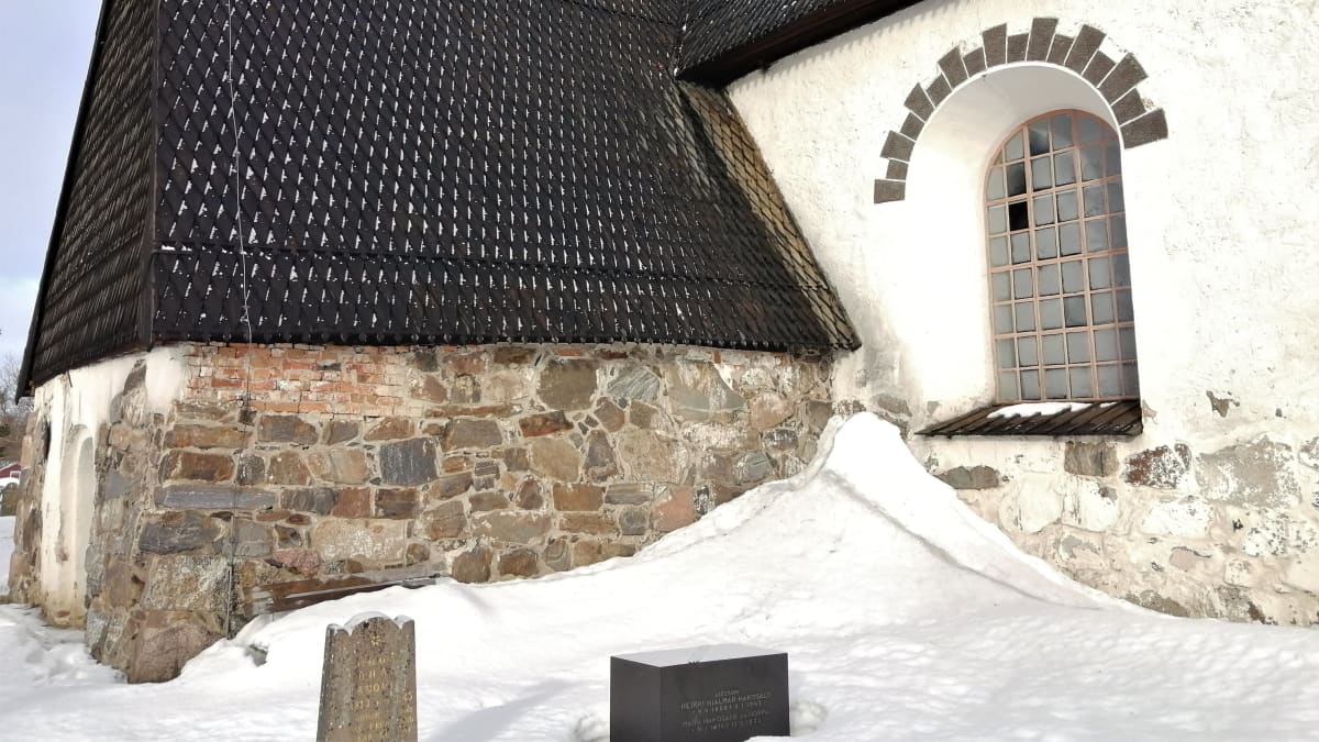 Isonkyrön vanha kirkko talvimaisemassa, lumikinokset yltävät lähes räystäisiin saakka.