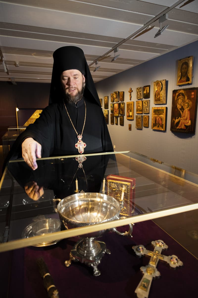 Arkkimandriitta Mikael esittelee vitriinissä olevaa vedenpyhitysastiaa Valamon luostarin museossa.