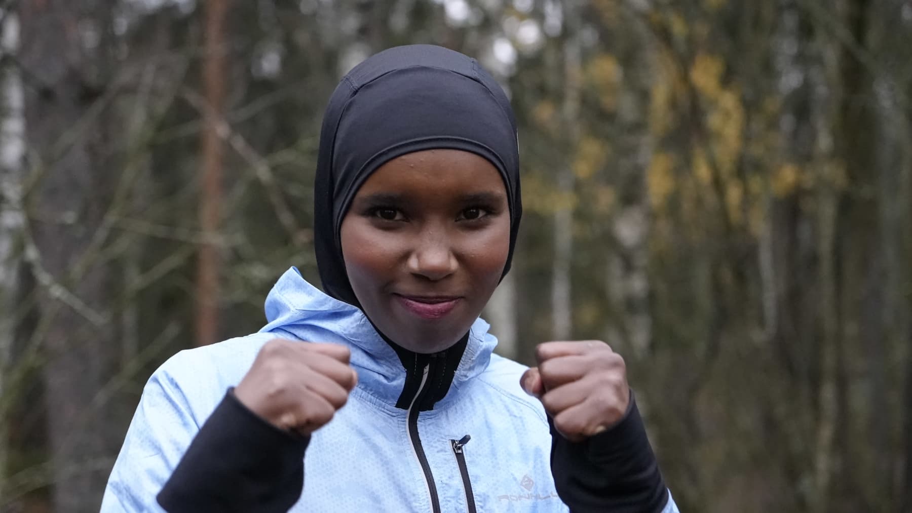 Hijab-huivia käyttävä Naiimo Bulhan katsoo kameraan ja pitää nyrkkejä ylhäällä.
