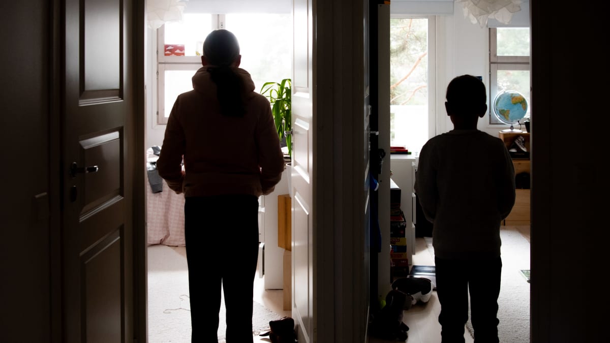 Kaksi lasta seisoo kahden huoneen oviaukoissa.