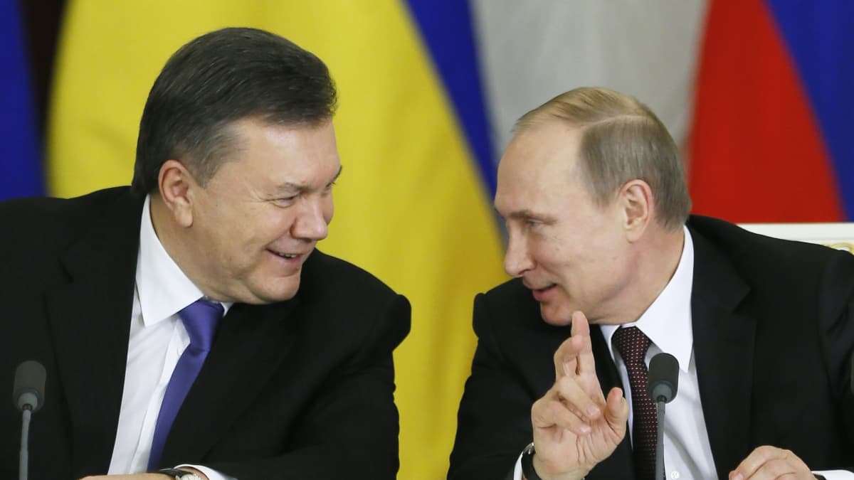 Viktor Janukovytšia ja Vladimir Putin juttelevat naureskellen. 