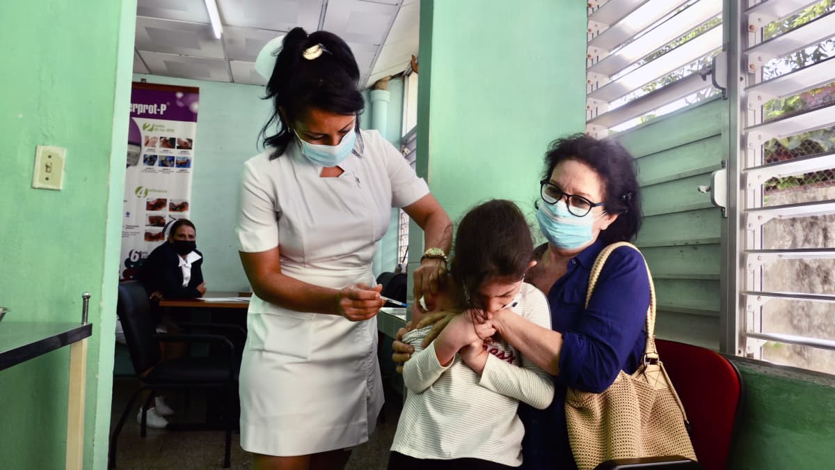 Sairaanhoitaja Miriam Fernandez antoi tottuneesti rokotteita klinikalle tuotaville lapsille. Rokotteen jälkeen lapset viedään katsomaan piirrettyjä puoleksi tunniksi, sen jälkeen pääsee kotiin.