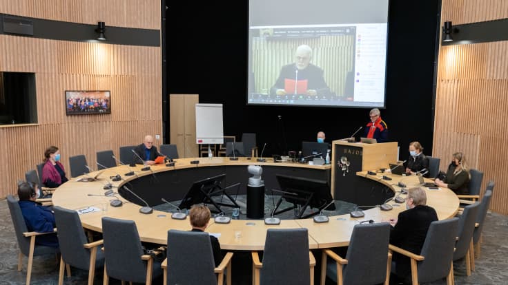 Saamelaisten totuus- ja sovintokomission jäsenet ovat kokoontuneet pyöreän pöydän ääreen Saamelaiskulttuurikeskus Sajokseen. Puhujanpöntön takana puheenvuoroa pitää Juha Guttorm.