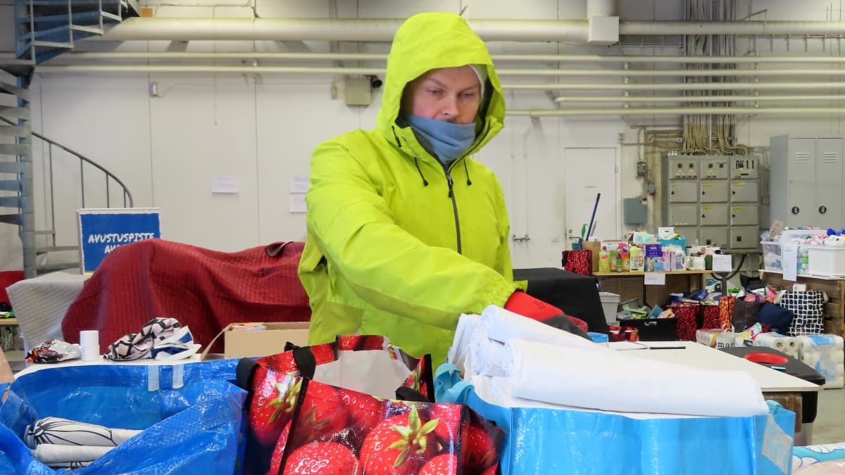 Mies lajittelee lahjoitukseksi saatuja tavaroita ukrainalaisten Turun avustuspisteessä.