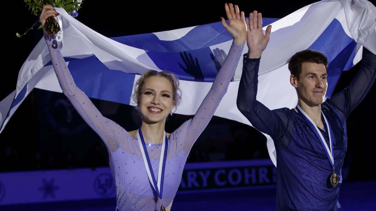 Juulia Turkkila ja Matthias Verlsuis Suomen lippujen kanssa.