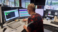 Mies käyttää radiostudion laitteita.