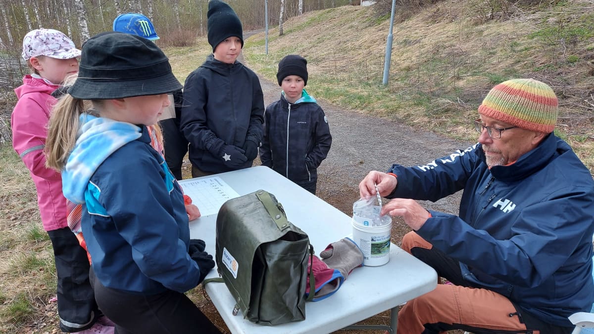 HAMK:n projektipäällikkö Mika Soramäki ja lapset tutkivat veden happipitoisuutta