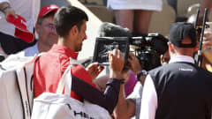 Novak Djokovic kirjoittaa kameran linssiin.