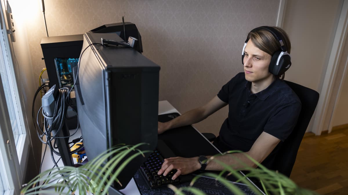 Juha-Pekka Palomaa pelaa tietokoneella kuulokkeet päässään. 