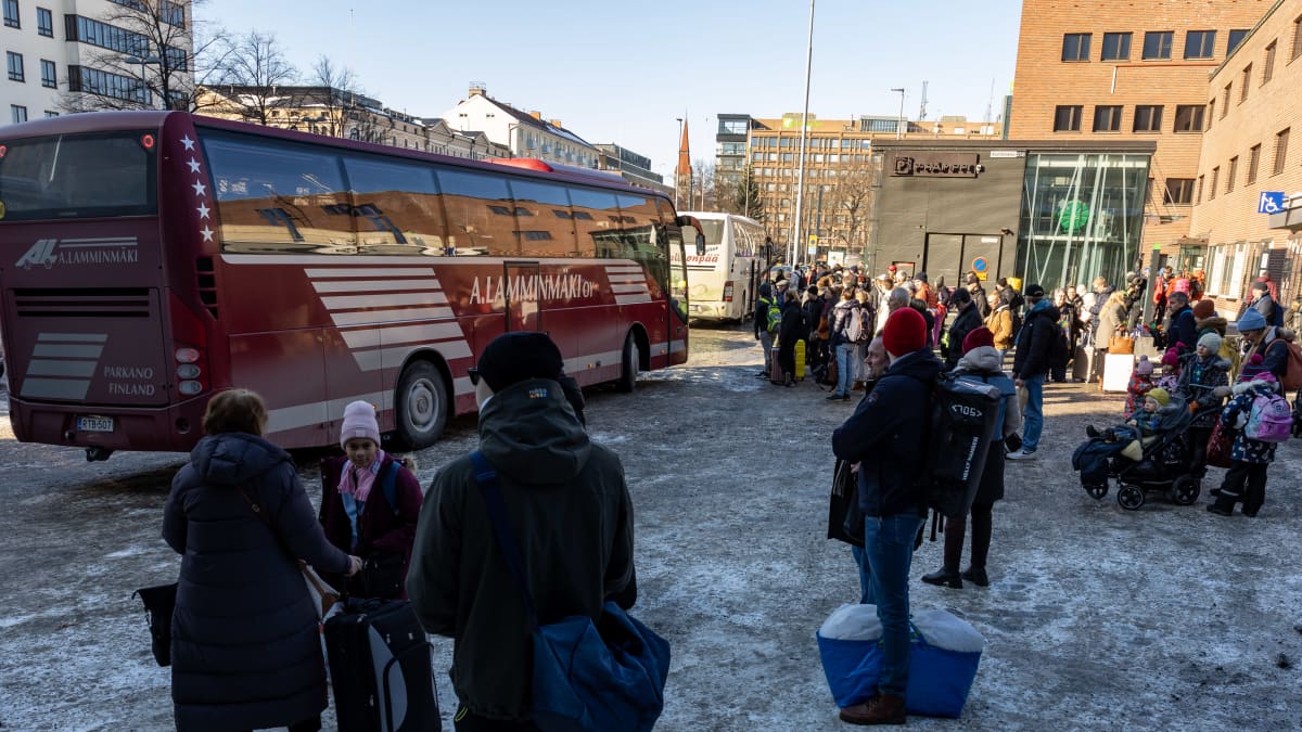 Ihmisiä Tampereen rautatieasemalla odottamassa pääsyä busseihin.