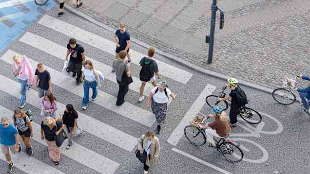Jalankulkijat ylittävät pyörätietä suojatiellä. Pyöräilijät odottavat pyörätiellä.
