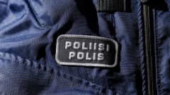 Yksityiskohta poliisin sinisessä virkapuvussa.