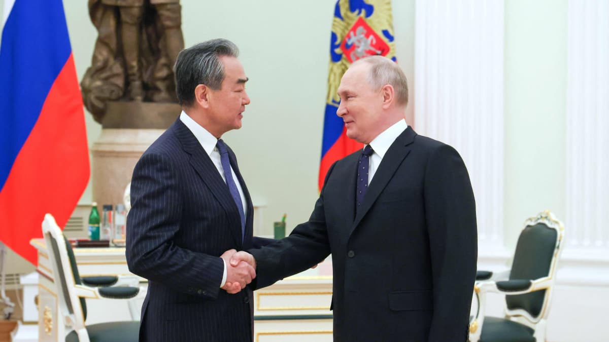 Wang Yi ja Vladimir Putin kättelevät. 