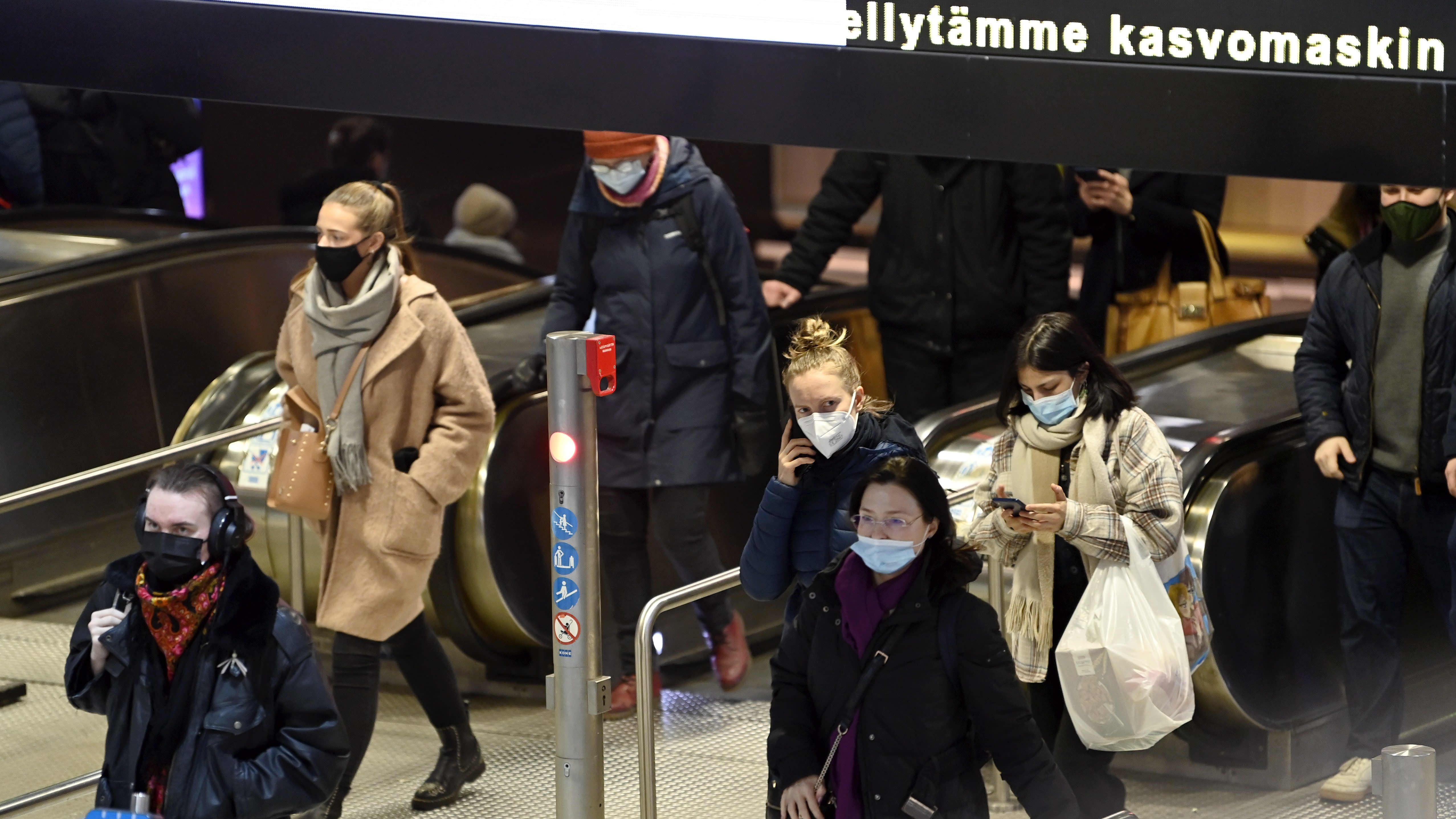 Maskia käyttäviä matkustajia Helsingin metroasemalla.