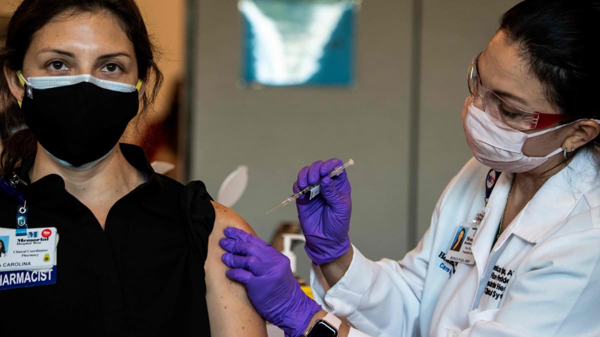 En kvinna som jobbar inom vården får en dos av Pfizer-Biontechs coronavaccin i Florida den 14 december 2020.