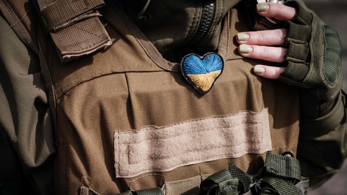 Sotilaan liivissä on kiinni punottu sydän Ukrainan väreissä.