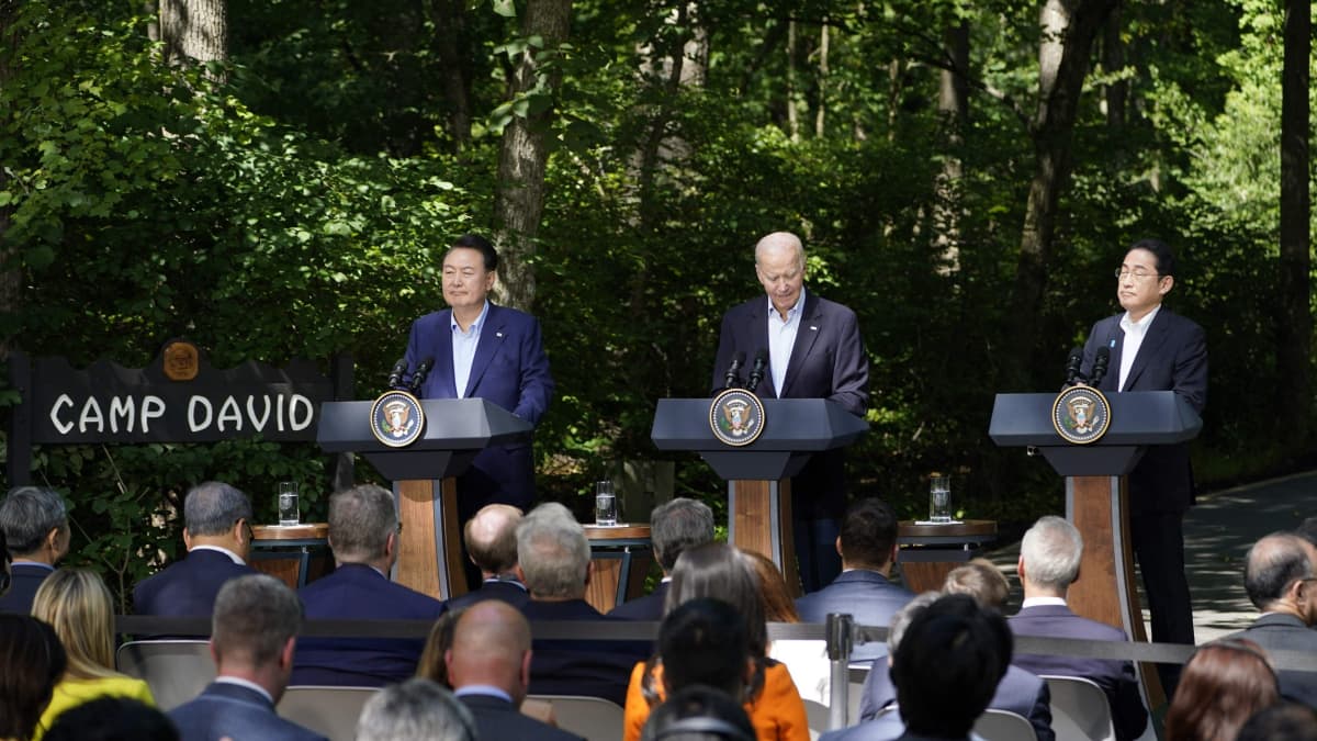 Yoon Suk Yeol, Joe Biden ja Fumio Kishida puhumassa.
