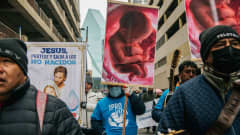 Mielenosoittajat (miehiä) vastustavat aborttia kylttejä kantaen.