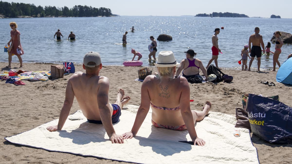 Auringon palvojia Aurinkolahden rannalla Helsingissä.