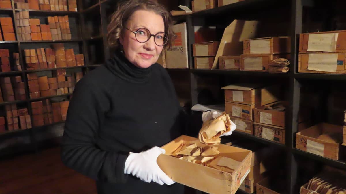 Nainen näyttää Turun tuomiokirkon haudoista löytyneiden esineiden säilytyskuoria.
