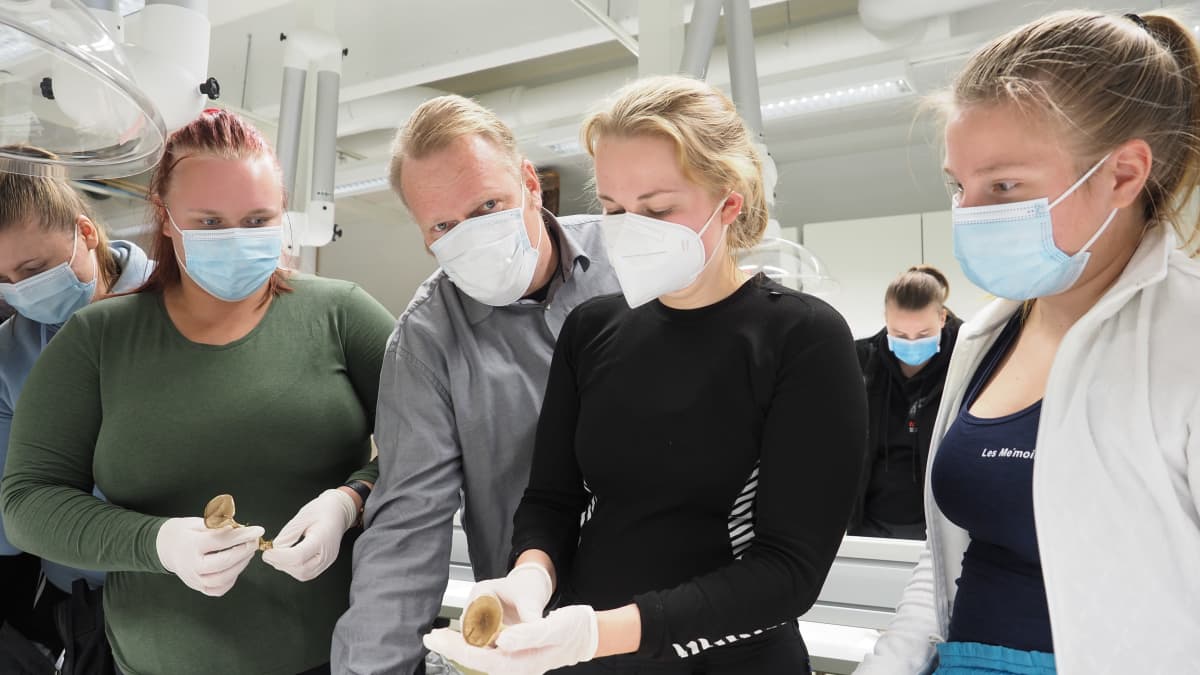 Itä-Suomen yliopiston opiskelijoita ja opettaja Vesa Paajanen tutustumassa sieniin oppitunnilla.