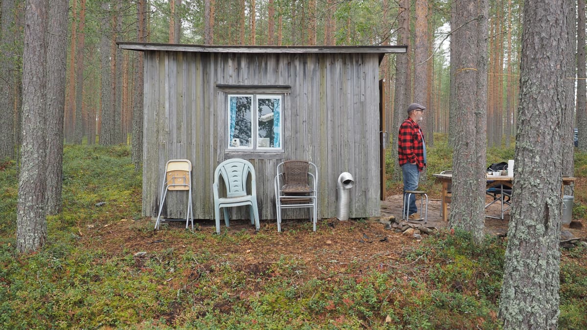 Mies pienen kesämökin ulkopuolella