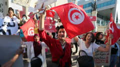 Mielenosoittajat heiluttivat Tunisian lippuja mielenosoituksessa 