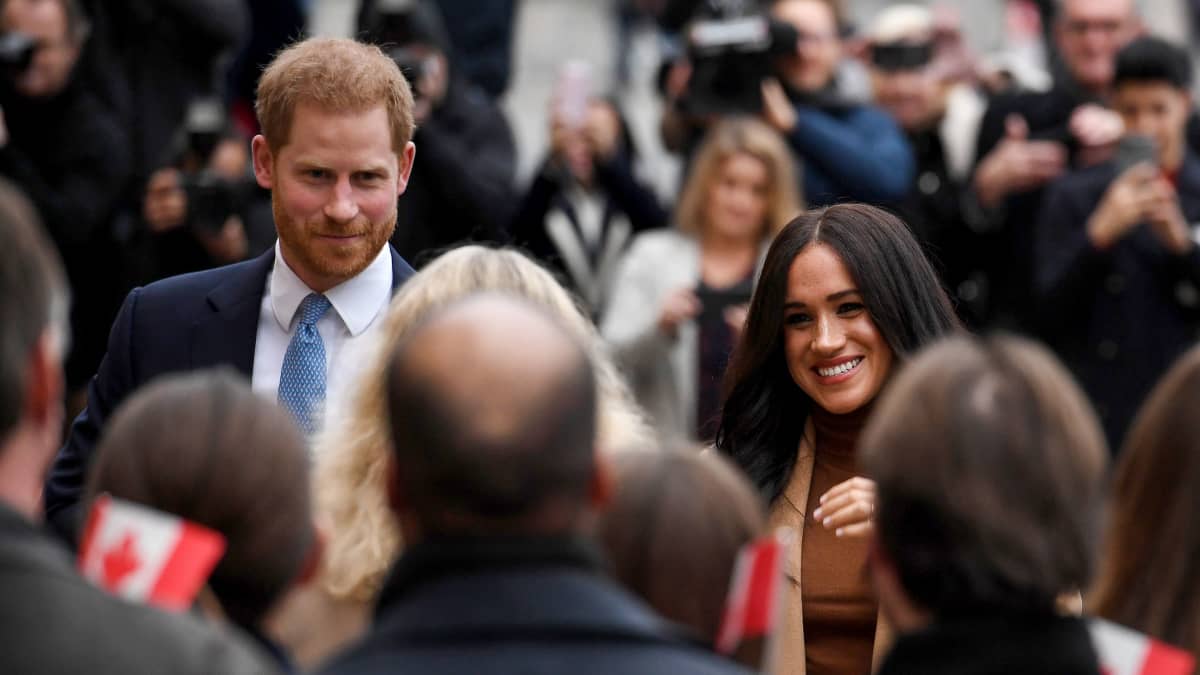 Prinssi Harry ja herttuatar Meghan ihmisjoukon takana. Etualalla pieni Kanadan lippu.