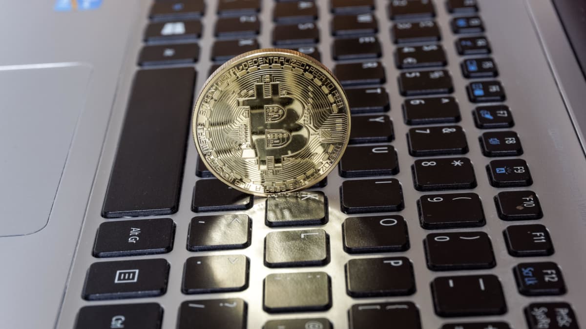 Bitcoin kryptovaluutan symboli tietokoneen näppäimistön päällä.