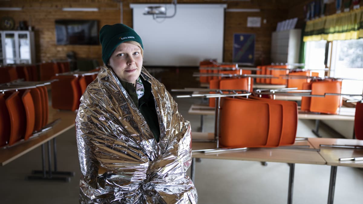 Kirsi Mäntysaari kietoutuneena hopeanväriseen pelastuspeittoon.