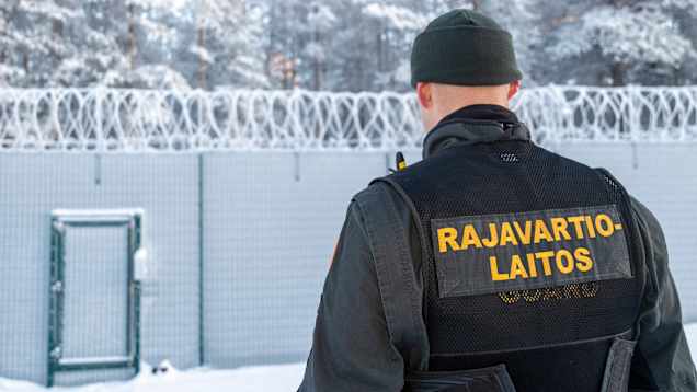Photo shows a border guard at a checkpoint.