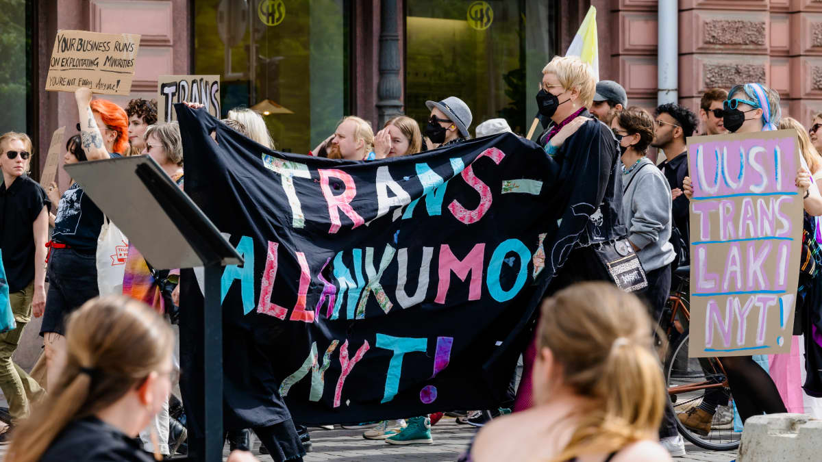 Mielenosoittajien kylteissä lukee "Trans-vallankumous nyt" ja "Uusi translaki nyt!".