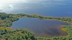 Pensaskari eli pieni järvi etualalla, taustalla merta
