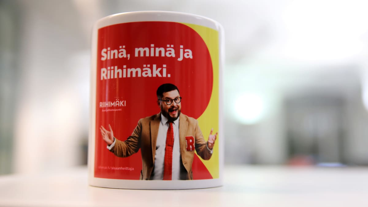 Riihimäen kaupungin mainosmuki, jonka punakeltaisella pohjalla Janne Katajan esittämä Sisäänheittäjä.
