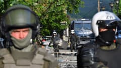 Nato-johtoiset KFOR-rauhanturvaajat Kosovon Zveçanissa 30. toukokuuta 2023. Taustalla näkyy myös poliisin kuorma-auto.