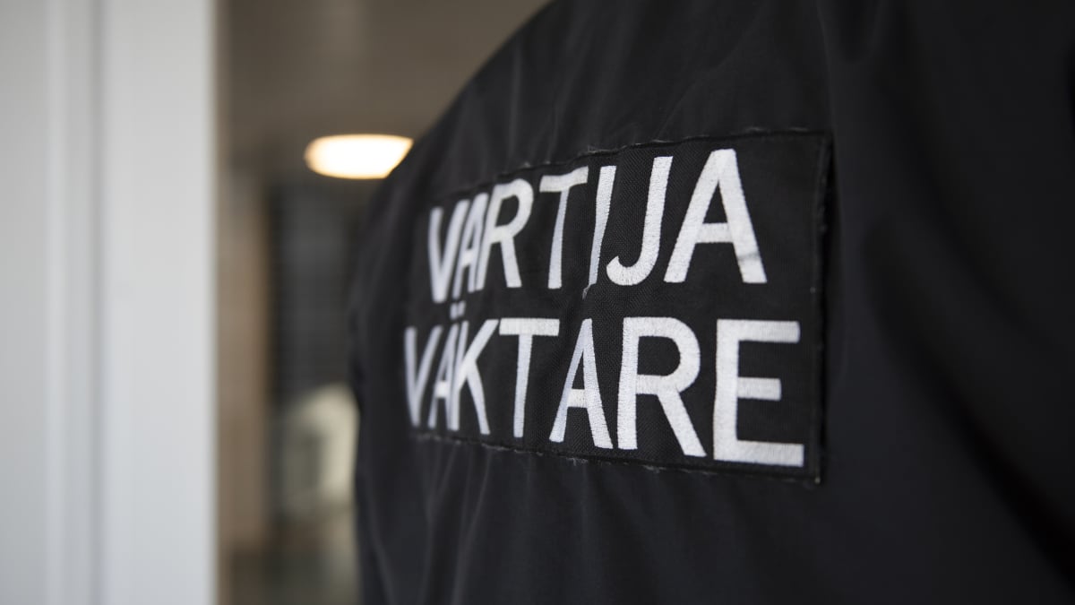 Vartijan selkä, jossa lukee suomeksi ja ruotsiksi vartija/väktare.