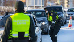 Rajavartiolaitos suorittaa rajatarkastuksia Torniossa viides helmikuuta. Taustalla liikenneruuhka.