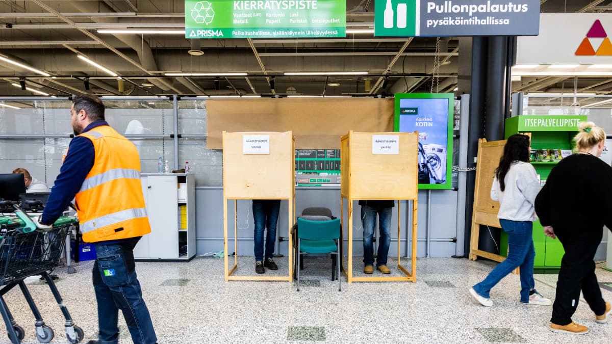 Äänestäjiä äänestämässä vaalikopissa Espoossa Olarin Prisman ennakkoäänestyspaikassa.