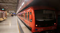 Oranssi metrojuna seisoo asemalla.