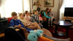 Ukrainasta Suomeen sotaa pakoon lähteneet kolme äitiä viiden lapsensa kanssa istuvat sohvalla hausjärveläisen talon sohvalla. 