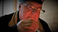 Jarmo Lampi sytyttää tulitikun saunassa.