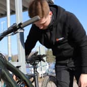 Jukka Lammi kiinnittää polkupyöräänsä lukkoa.