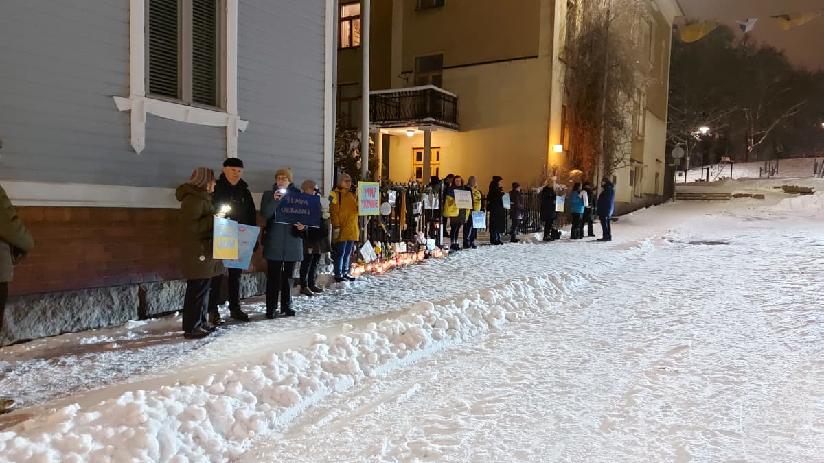 Mielenosoittajia Venäjän konsulaatin edustalla Turun Vartiovuorenkadulla. Maassa on lunta. Taustalla ruskea jugend-talo. Mielenosoittajia seisoo kadulla 15.