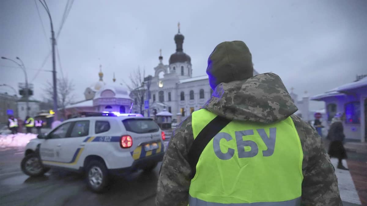 En polis vid säkerhetstjänsten SBU övervakar trafiken medan en räd pågår i Kiev.