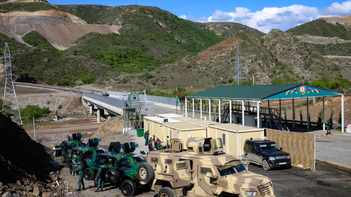 Raja-asema Vuoristo-Karabahissa, edustalla ruskeita ja vihreitä sotilasajoneuvoja.